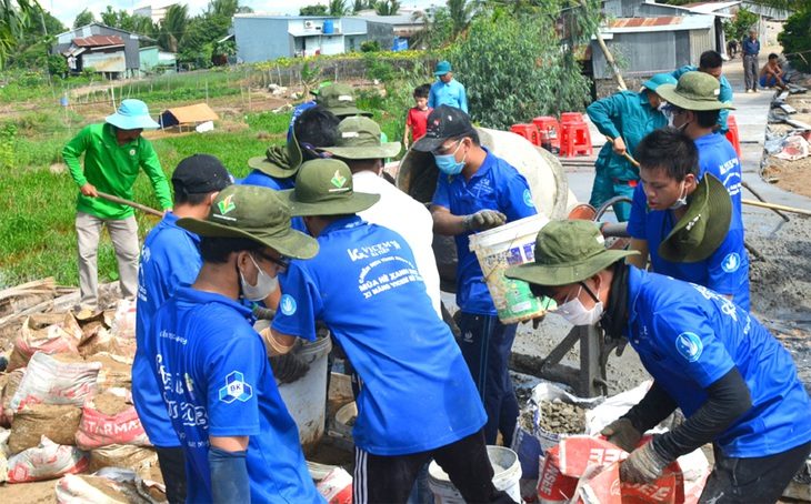 Chiến sĩ Mùa hè xanh Bách khoa cùng bà con làm đường bê tông bờ tây kênh Phước Xuyên tại xã Tân Phước, huyện Tân Hồng (Đồng Tháp) - Ảnh: ĐẶNG TUYẾT